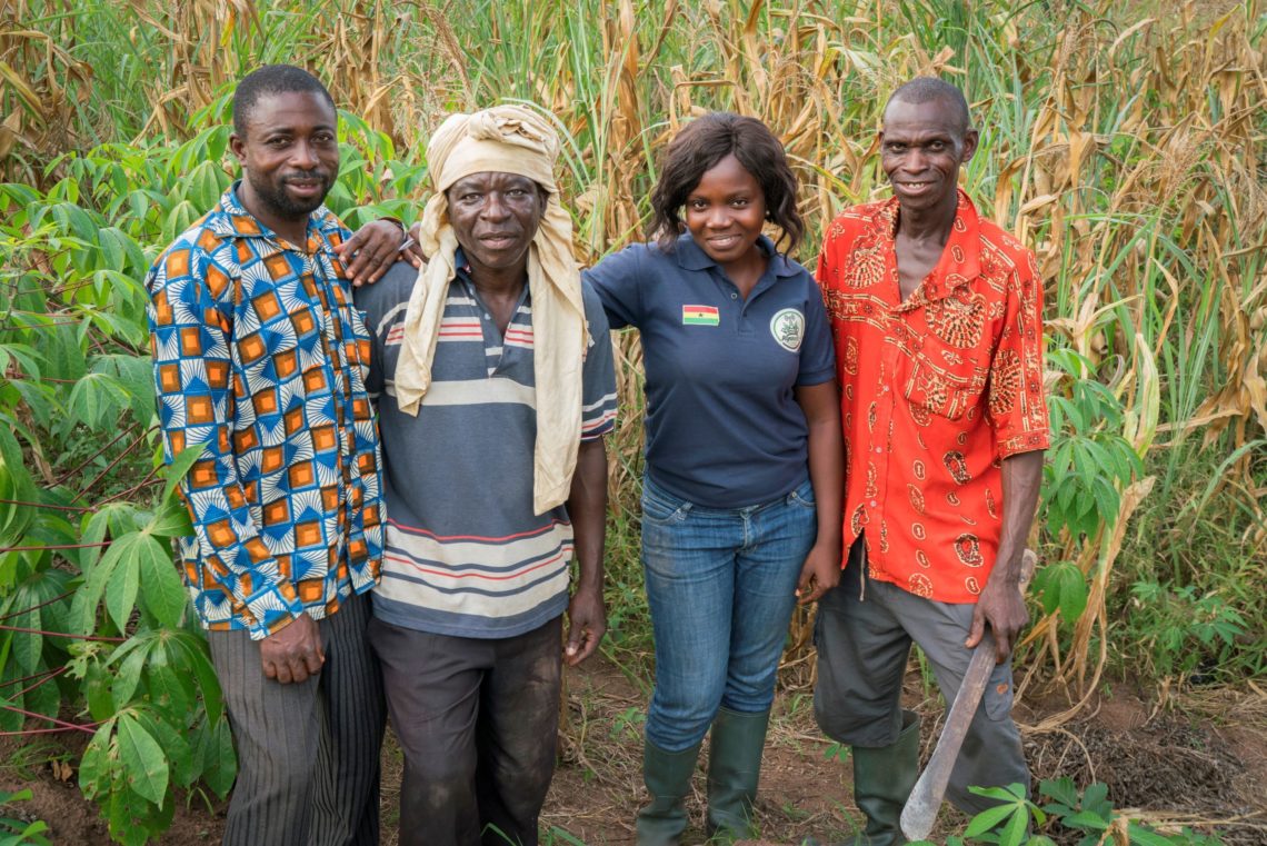 Racheal, a Grameen Foundation Community Agent, stands with three of her smallholder farmer clients on a cocoa farm in Ghana.