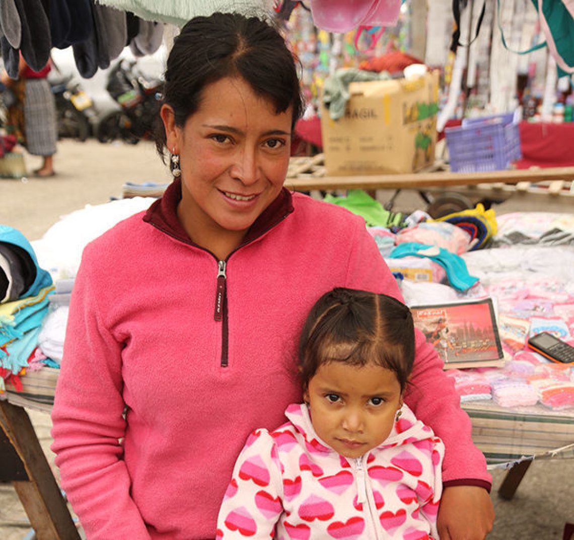 Teresa, a RICHES group participant from El Salvador, and her daughter. Teresa is wearing a pink sweater, and her daughter is wearing a white sweater with pink hearts.