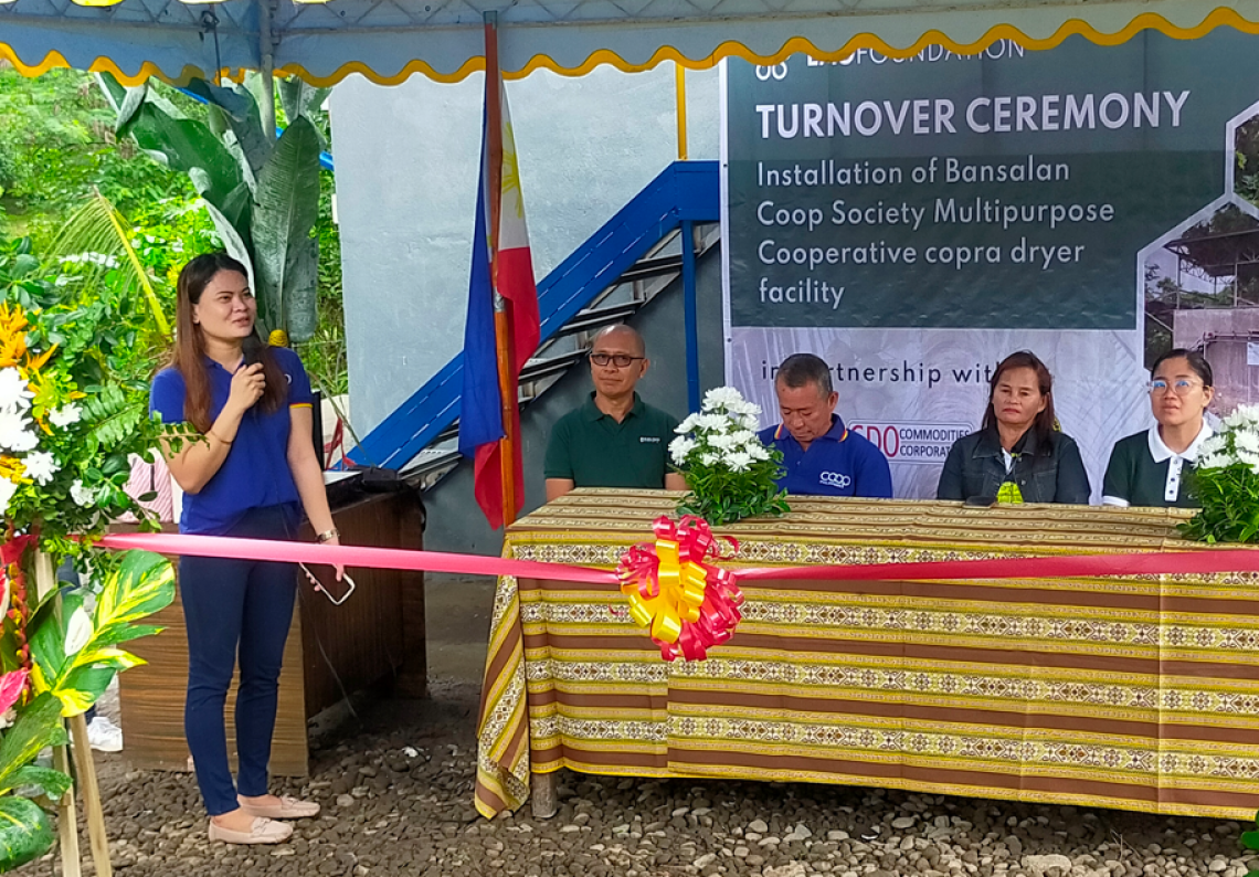 Michelle Laina stands and speaks to a group during the turn-over ceremony of the drying facility donated by Lao Foundation - CDO Commodities and Oleo Fats Corp. at BCSMPC copra processing site in Bansalan, Davao City in July 2024.
