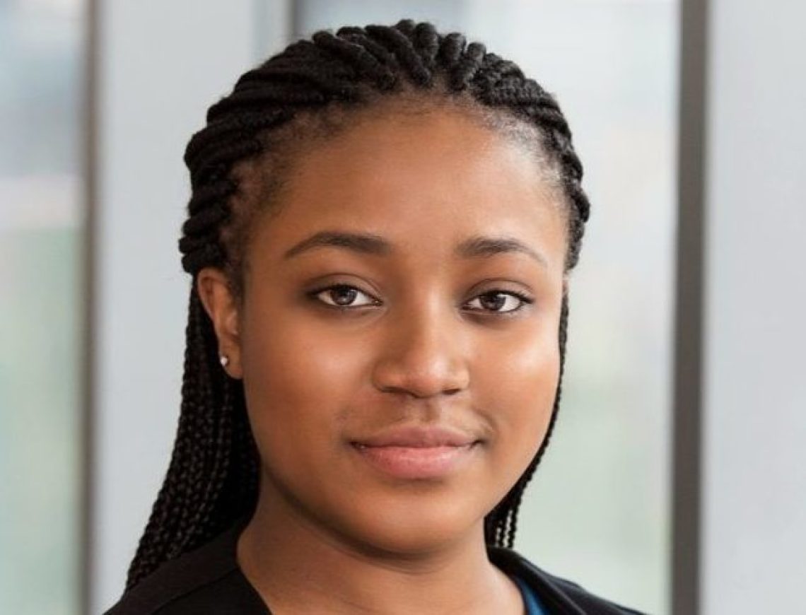 Shown is Nadeige Uwamba- a Black woman with her hair pulled back, wearing a blue shirt and black jacket.