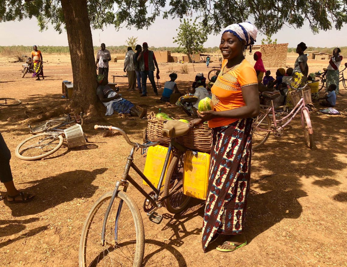 Woman standing next to bikes Burkina Faso camp