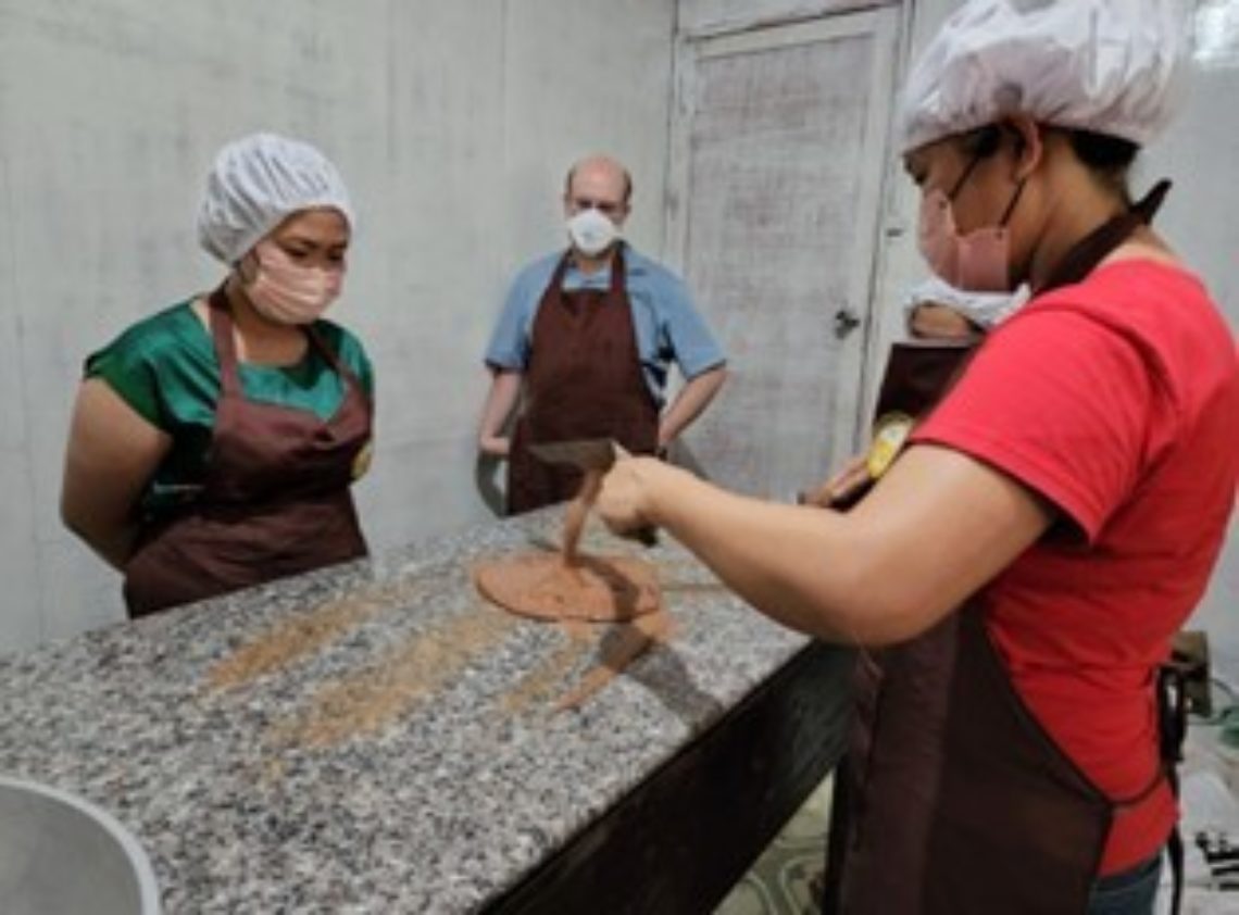 Joyce training her colleagues on the cacao production process.