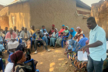 Grameen Foundation Facilitates An Outdoor Dialogue Training For A Group Of Seated People