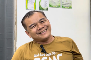 An image of Reynante Madelo - a man wearing a yellow shirt with short hair and smiling