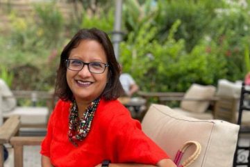 Photo of Grameen Foundation President and CEO, Sabrina Quarishi. Sabrina is seated and wearing a red shirt.