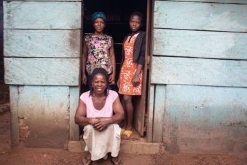 Comfort sitting in her door step with two daughters