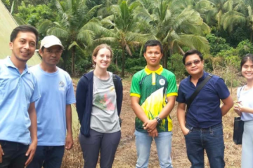 F2F volunteer Chelsea Johnson stands with farmers in the Philippines