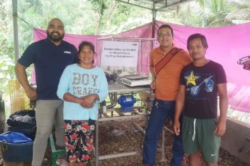 Michael Pascual, F2F recruiter, BWB volunteer Porter Long, and two coconut farmers stand next to a table