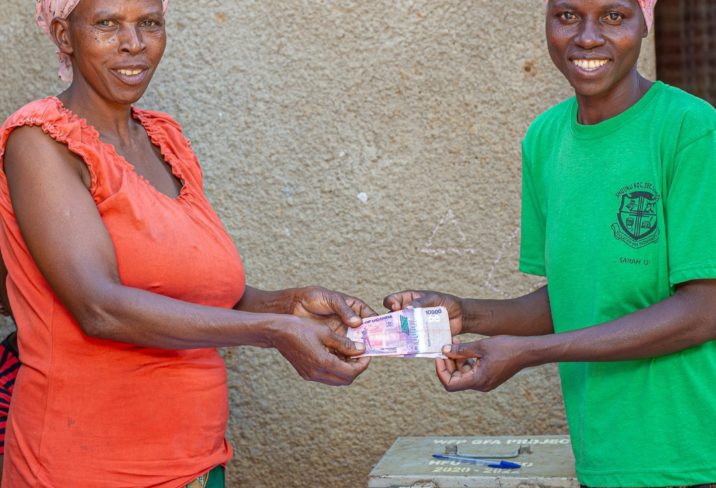 Two women exchange money in Nakivale Settlement, Uganda