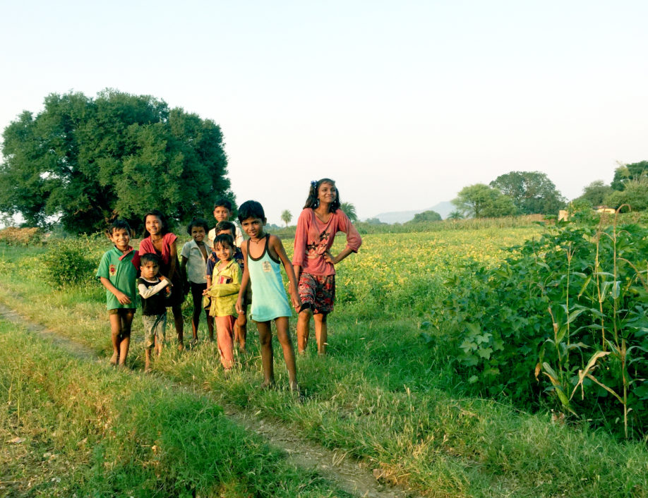 Schoolchildren in India smiling in field