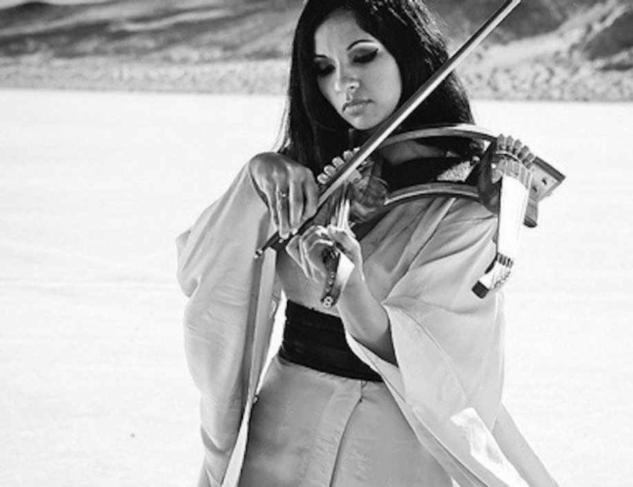Image of Gingger Shankar playing the double violin against a desert background