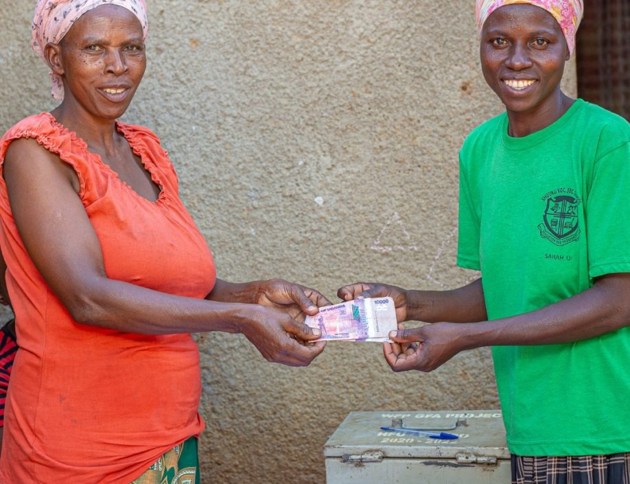 Two women exchange money in Nakivale Settlement, Uganda